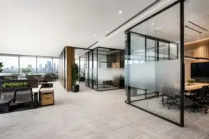 Modern office partition design in a Melbourne commercial workspace featuring frameless and aluminium-framed glass office partitions, frosted meeting rooms, open-plan workstations, timber finishes, and contemporary office fit-out design.